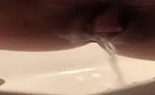 Shaved babe pooping in close up
