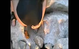 Shitting outdoor on a rock